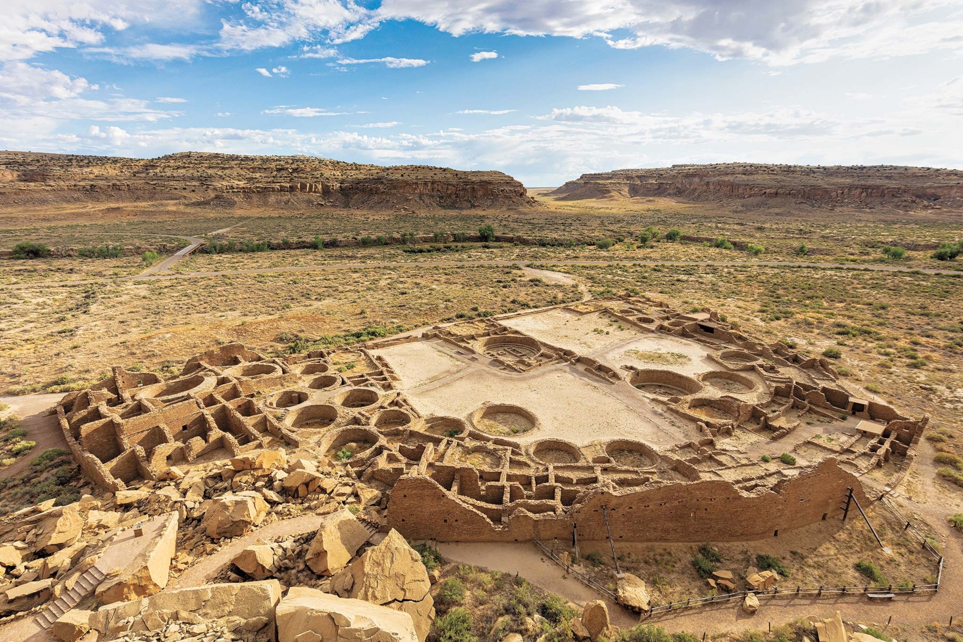 Một góc nhìn từ trên không của kivas nghi lễ của Chaco Canyon, hay các phòng, với những tảng đá đỏ ở đằng xa