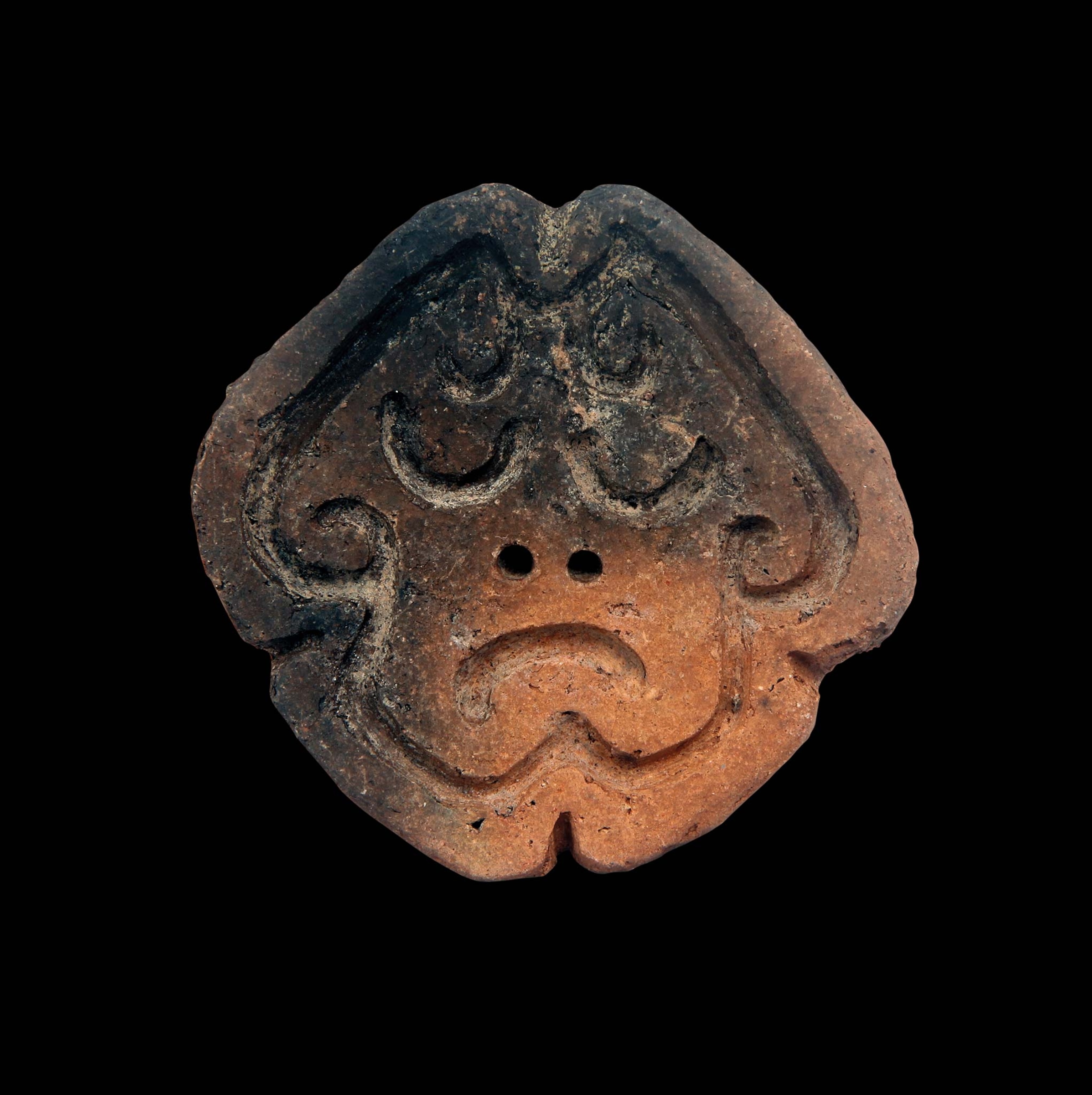 A ceramic stamp of a human face